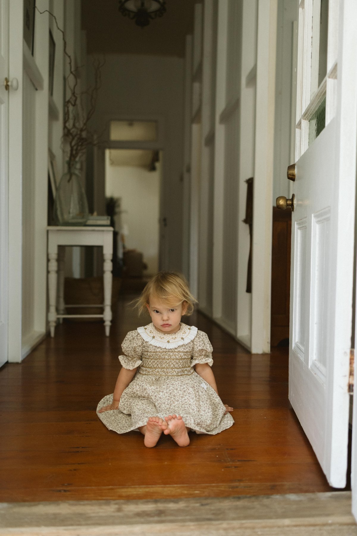 Kid sitting on the floor in a dress