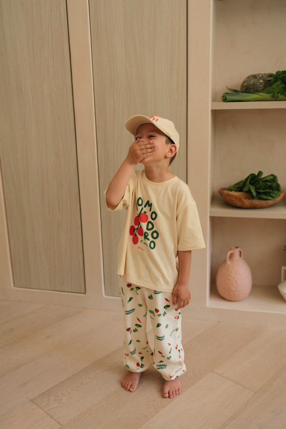 Kid in a printed tee and cap