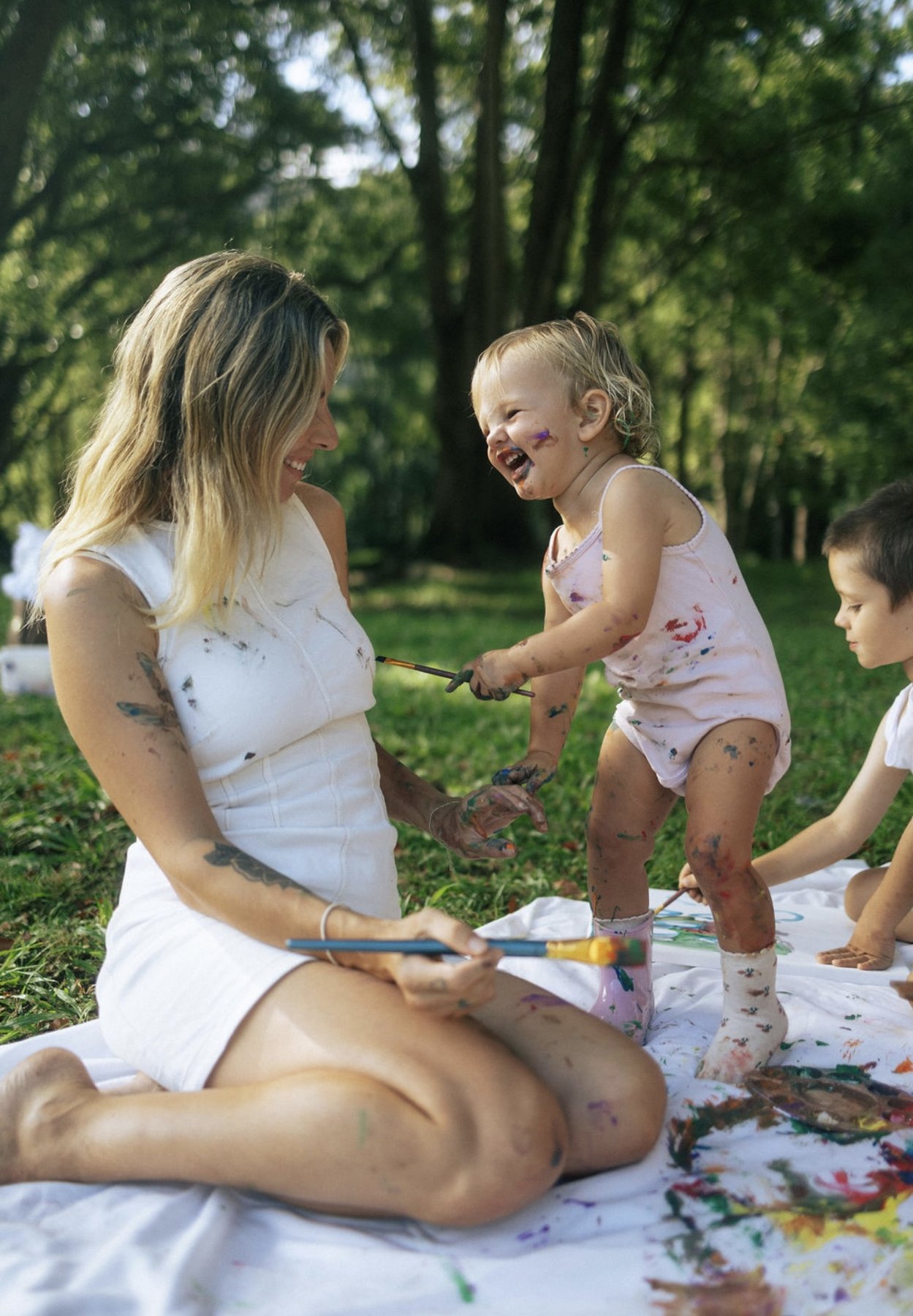 Rebecca laughing with her kids, covered in paint